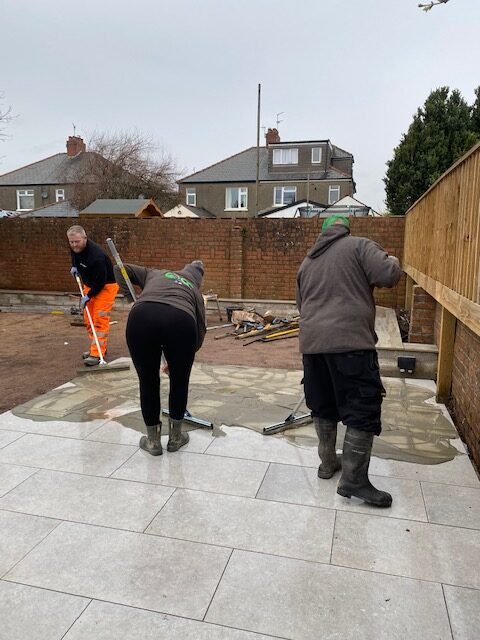 The team applies Flowpoint with rubber squeegees